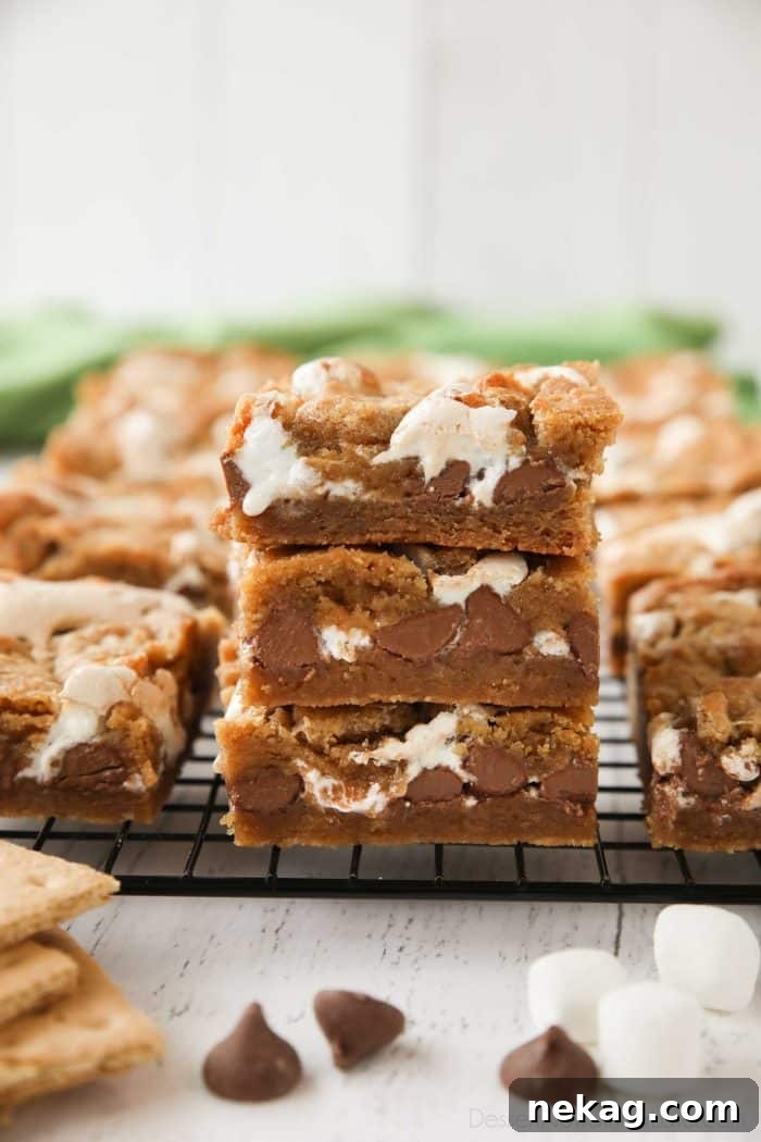 S'mores Bar Recipe: Chewy Graham, Chocolate & Toasted Marshmallow 2 Three S'mores Bars stacked with marshmallow fluff and chocolate chips oozing out.