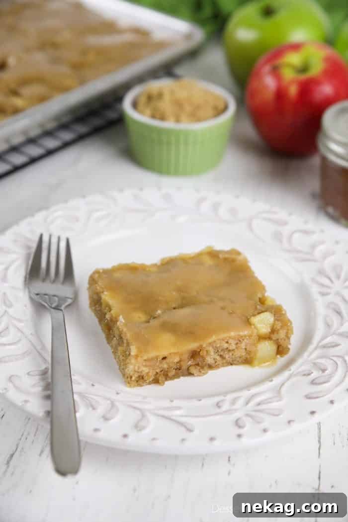 Brown Sugar Glazed Apple Sheet Cake Recipe 10 Slice of brown sugar glazed apple sheet cake on a plate with a fork.