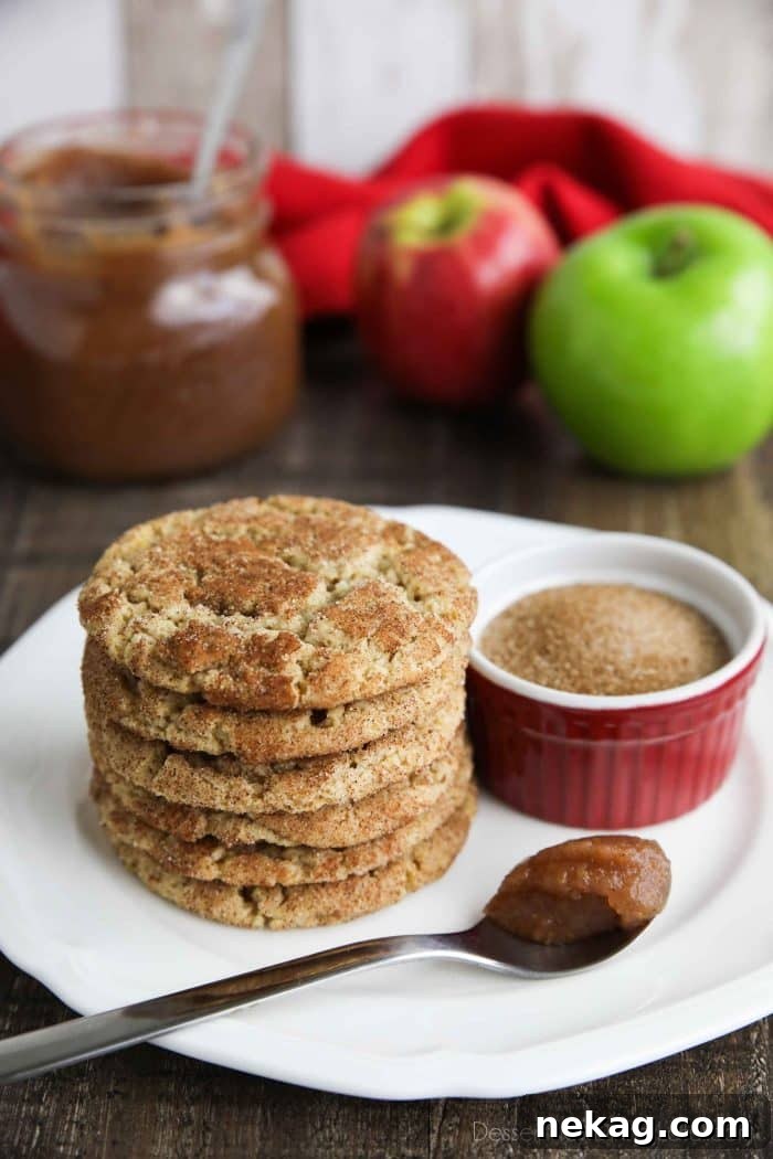 Apple Butter Cookies Recipe with Video Tutorial 4 Cookies stacked on top of each other next to a spoonful of apple butter and bowl of cinnamon sugar.