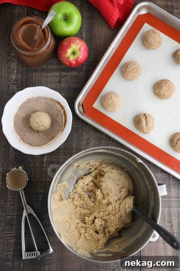 Apple Butter Cookies Recipe with Video Tutorial 6 Cookie dough shaped into balls that have been coated in a bowl of cinnamon sugar.