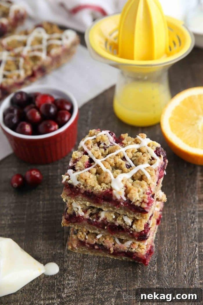 Cranberry Crumble Bars stacked with glaze drizzled on top.