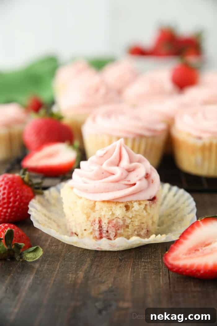 Fresh Strawberry Cupcakes with Real Fruit Frosting 2 Strawberry cupcake in wrapper with strawberry buttercream on top.