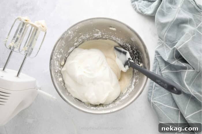 Whipped Cream Cheese Frosting Recipe (Video Tutorial) 11 Combining the whipped cream and cream cheese mixture.