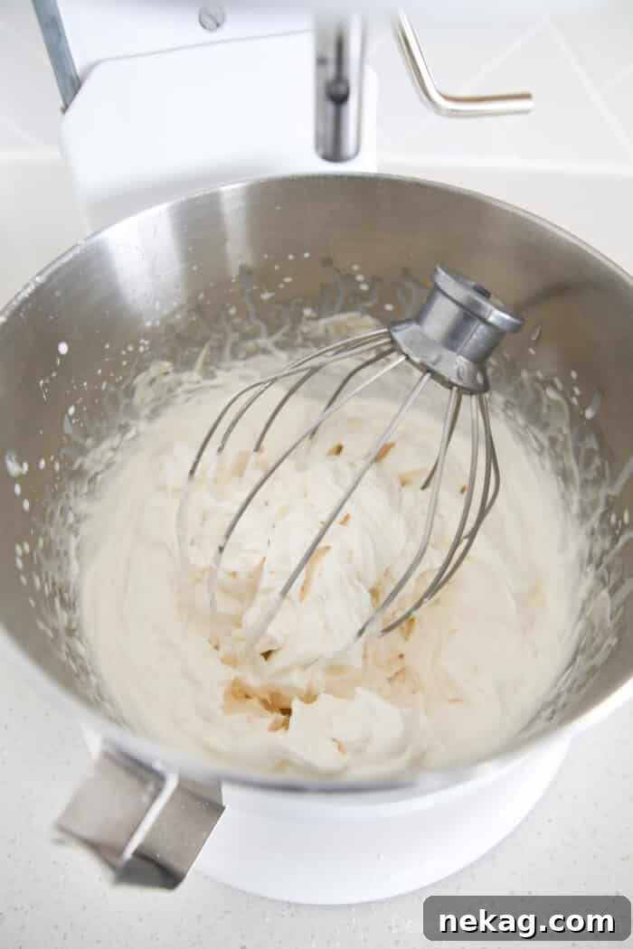 Whipped Cream Cheese Frosting Recipe (Video Tutorial) 12 Whisk full of whipped cream cheese frosting in the mixing bowl.