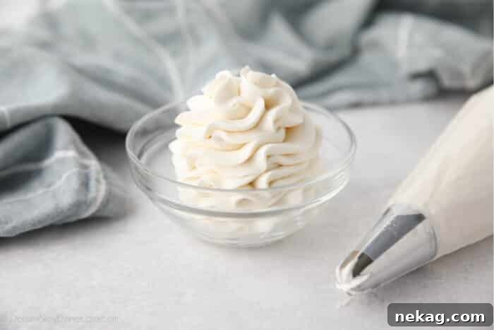 Whipped Cream Cheese Frosting Recipe (Video Tutorial) 6 Whipped Cream Cheese Frosting piped high into a clear glass bowl.