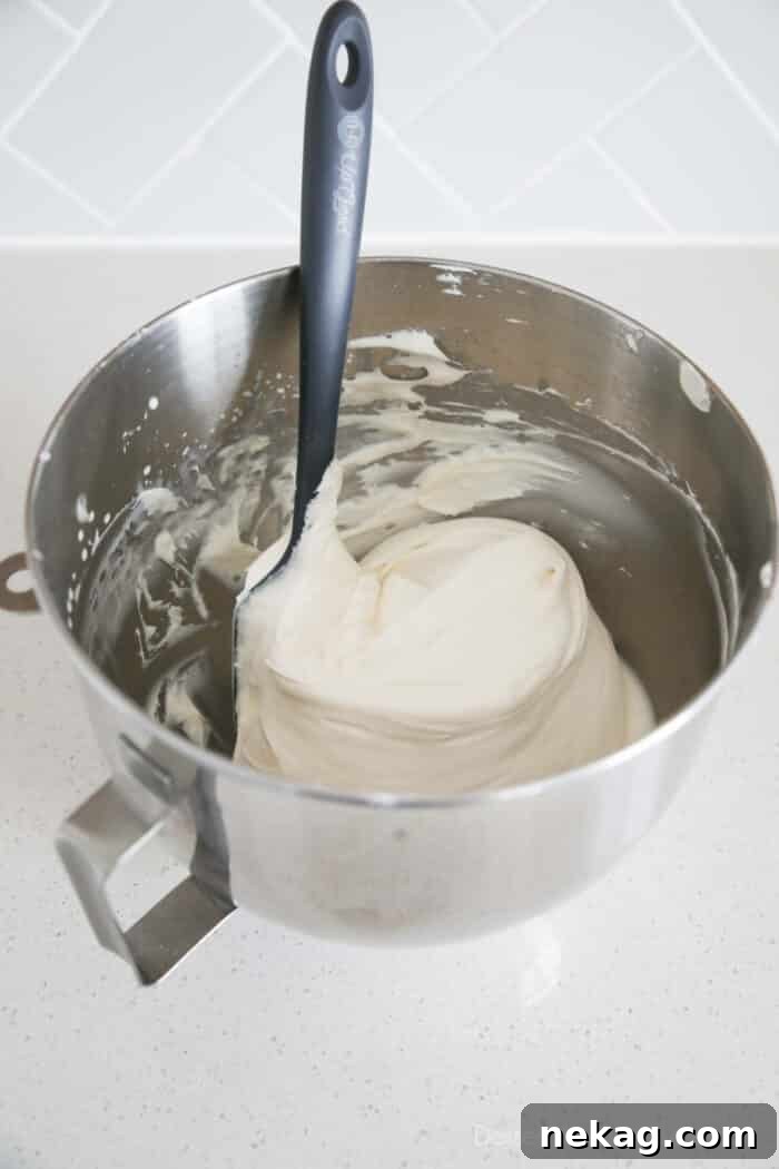Whipped Cream Cheese Frosting Recipe (Video Tutorial) 9 Whipped cream cheese frosting in mixing bowl with spatula.