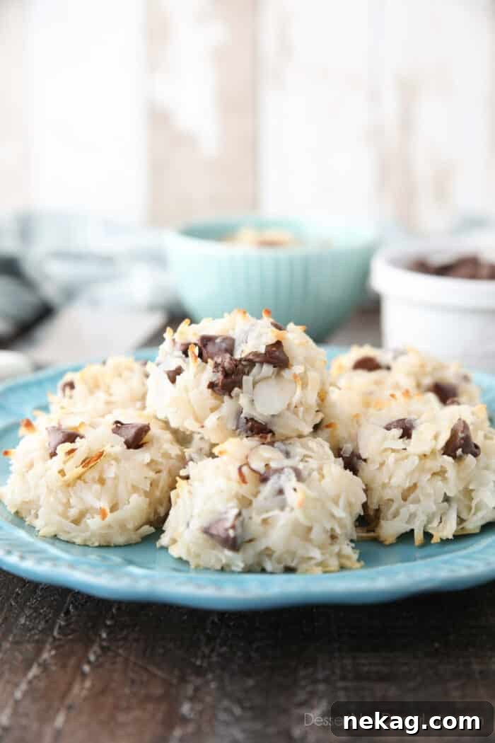 Almond Joy Cookie Recipe with Coconut, Almonds & Chocolate Chips 3 Side view of a plate of coconut macaroons with almonds and chocolate chips.