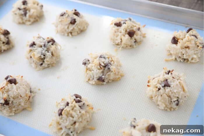 Almond Joy Cookie Recipe with Coconut, Almonds & Chocolate Chips 8 Baked almond joy cookies on a sheet tray.