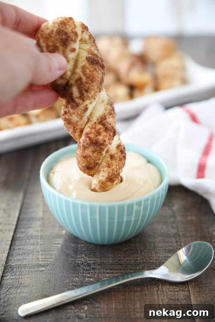 Cinnamon Twists Recipe: Crispy, Flaky Pastry with Sweet Glaze 4 Dipping a cinnamon breadstick into a bowl of cream cheese glaze.