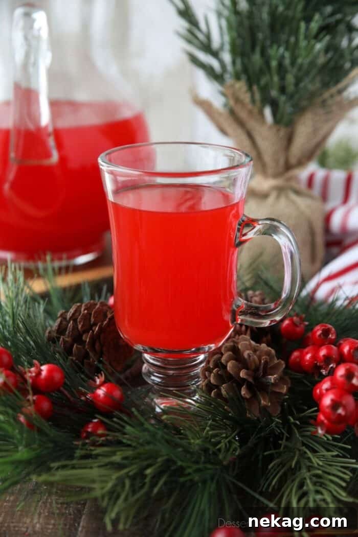 Close up of a glass cup with red holiday punch inside it.