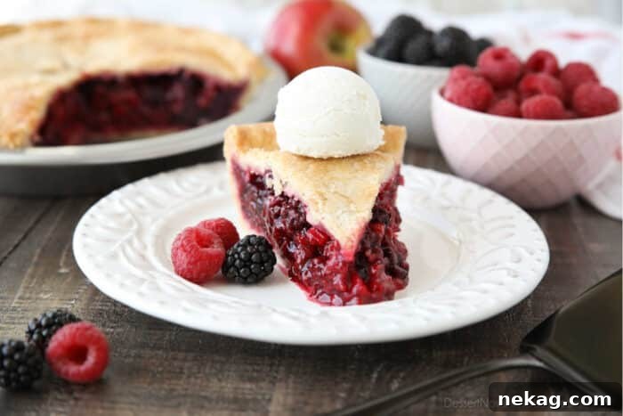 Razzleberry Pie Recipe with Step-by-Step Video Tutorial 4 Slice of Razzleberry Pie on a plate topped with ice cream. Focus is on the berry pie filling.