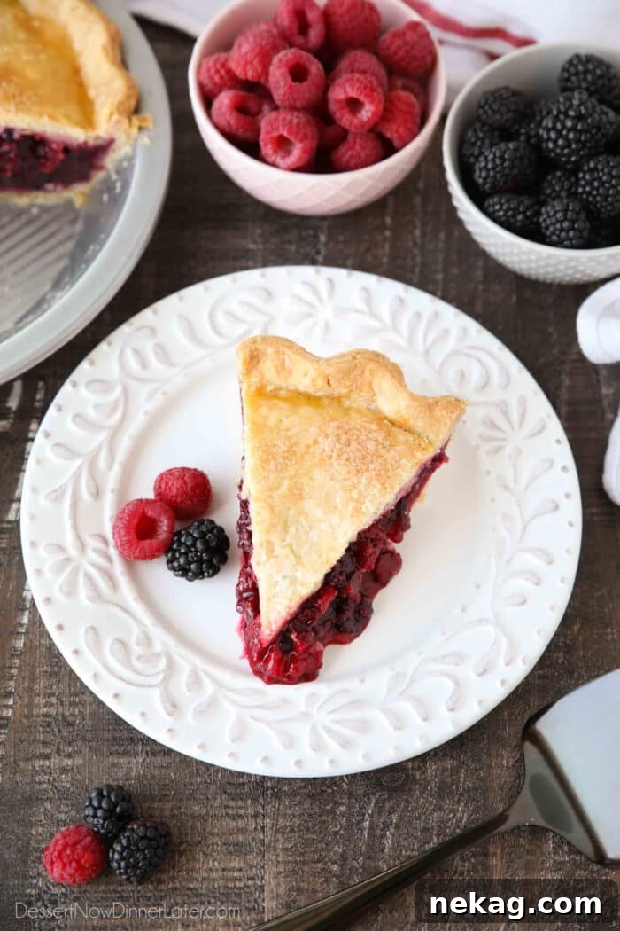 Razzleberry Pie Recipe with Step-by-Step Video Tutorial 5 Top view of a slice of mixed berry pie in homemade crust.