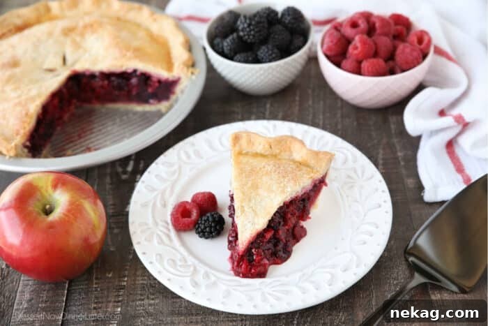 Razzleberry Pie Recipe with Step-by-Step Video Tutorial 6 Slice of razzleberry pie on plate with raspberries and blackberries.