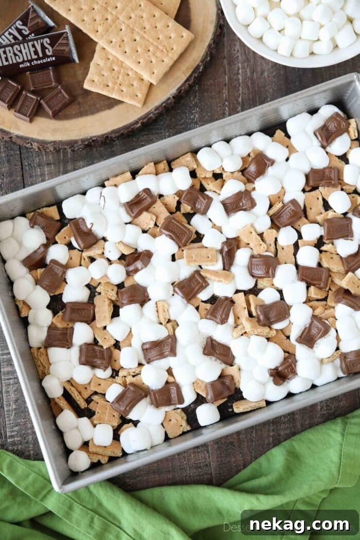 S'mores Brownies Recipe: Gooey Chocolate Graham Bar Squares 4 Top view of melted marshmallows and chocolate bars with graham cracker pieces on top of baked brownies.