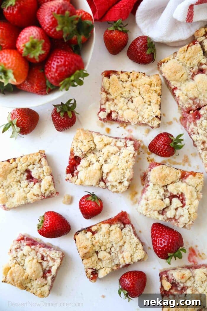 Chewy Strawberry Crumb Bars with Perfect Jam Layer 3 Strawberry Crumb Bars cut into squares with fresh strawberries.