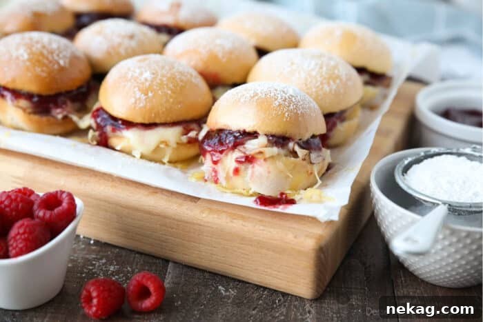 Crispy Monte Cristo Sliders with Ham, Turkey & Melty Cheese 8 Warm Monte Cristo Sliders on top of a cutting board.