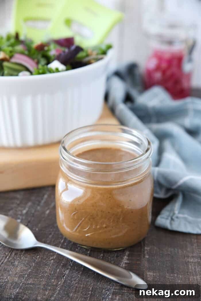 Mason jar with creamy balsamic dressing and a spoon.