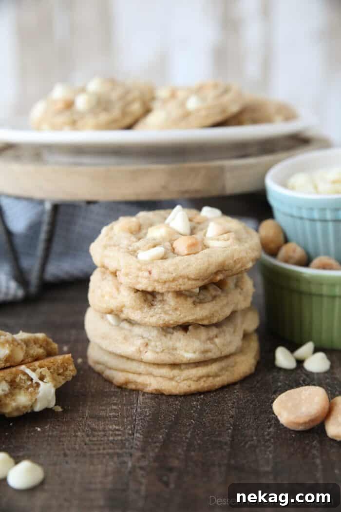 White Chocolate Macadamia Nut Cookie Recipe for Chewy Crispy Cookies 5 Stacked White Chocolate Macadamia Nut Cookies with extra nuts and white chocolate chips on the side.