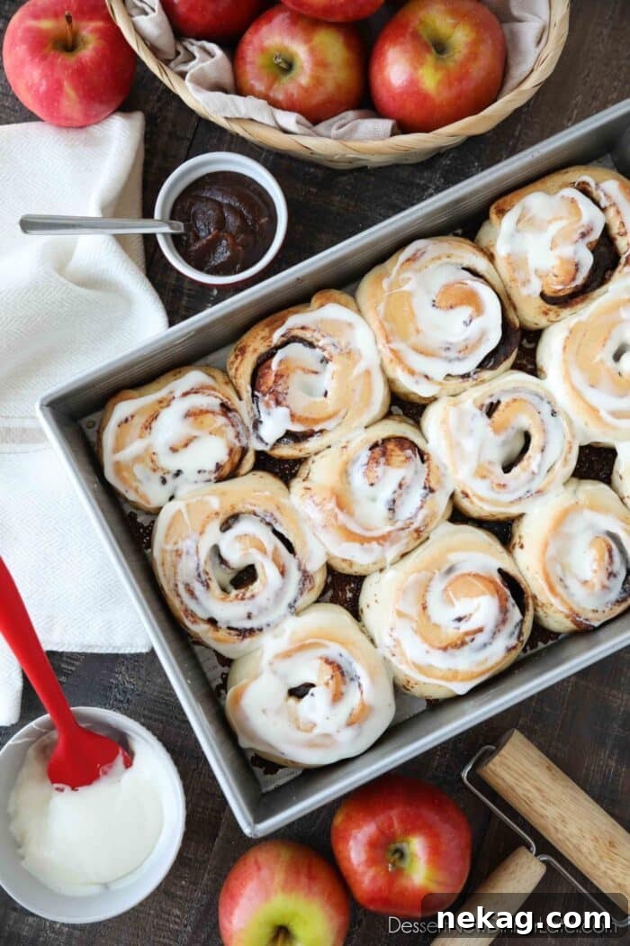 Baked Apple Butter Cinnamon Rolls in pan with cream cheese glaze.