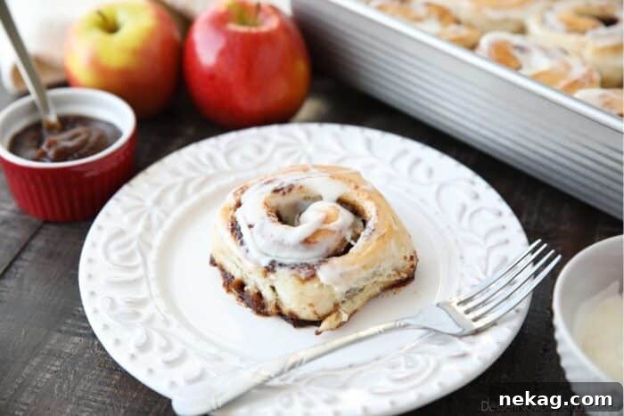 Side view of an apple butter cinnamon roll on a plate.