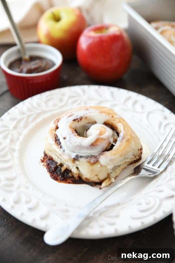 Apple Butter Cinnamon Roll on plate with a fork.