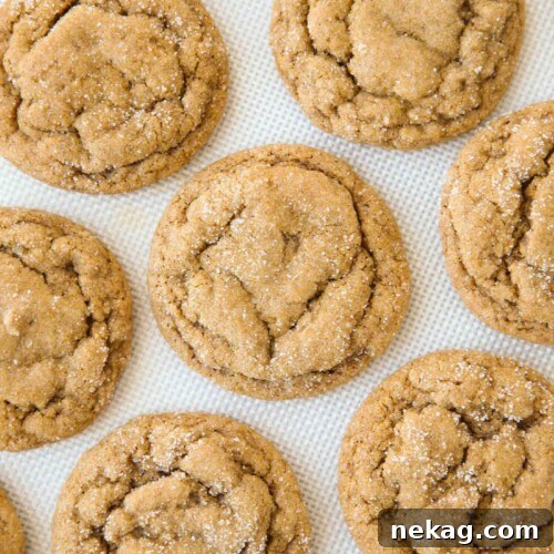 Chewy Pumpkin Gingersnap Cookies with Warm Spices 8 Baked pumpkin gingersnap cookies on a silicone baking mat.