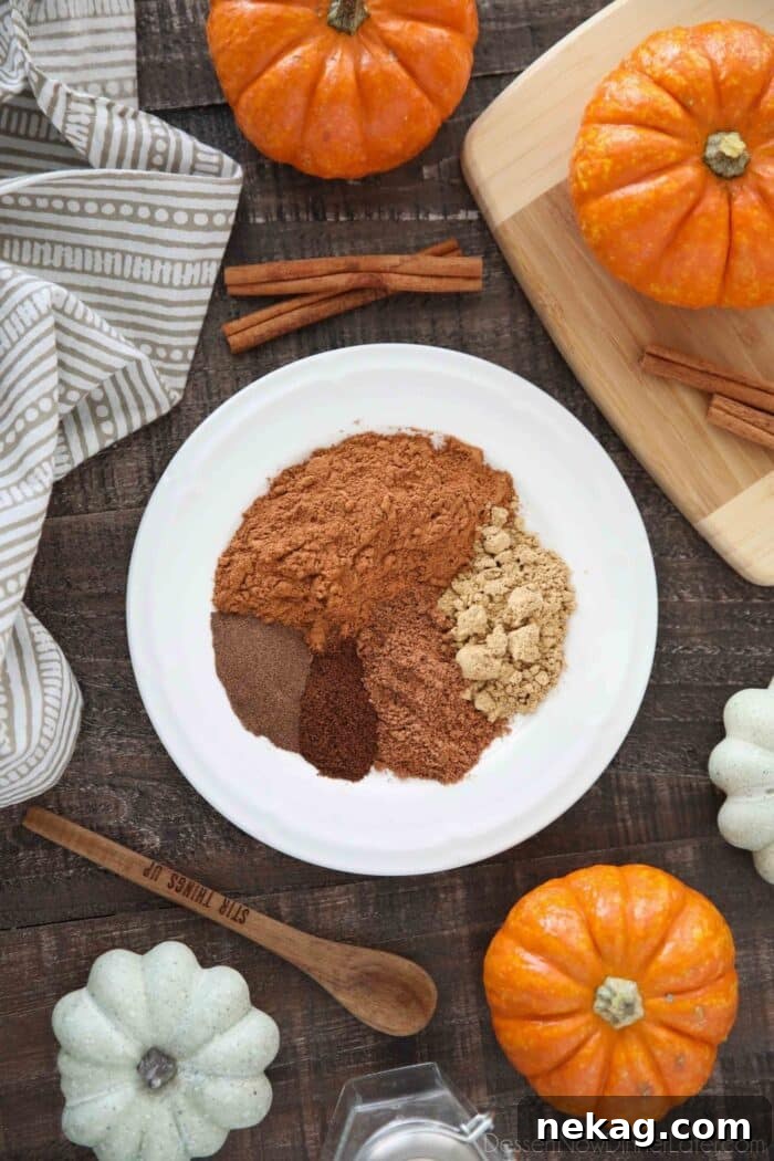 How to Make Homemade Pumpkin Pie Spice Blend for Fall Baking 4 Ingredients on a plate for pumpkin pie spice recipe: ground cinnamon, ground ginger, ground nutmeg, ground cloves, and ground allspice.