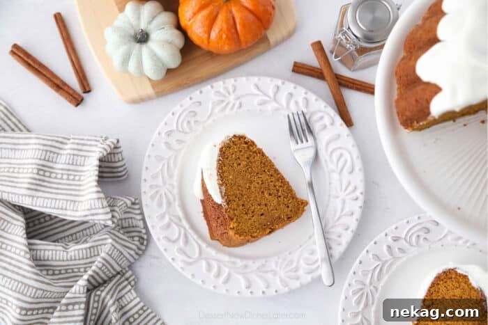 Moist Pumpkin Bundt Cake with Warm Spice Glaze 5 Top view of a slice of pumpkin bundt cake with cream cheese frosting on a plate with a fork.