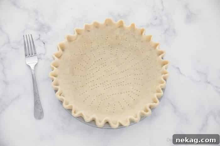 Unbaked pie crust with holes poked in the bottom and sides.
