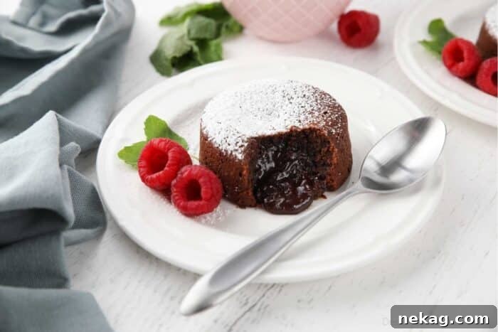 Molten Chocolate Lava Cake Recipe with Step-by-Step Video 11 A bite taken out of a chocolate lava cake with a pudding-like center.