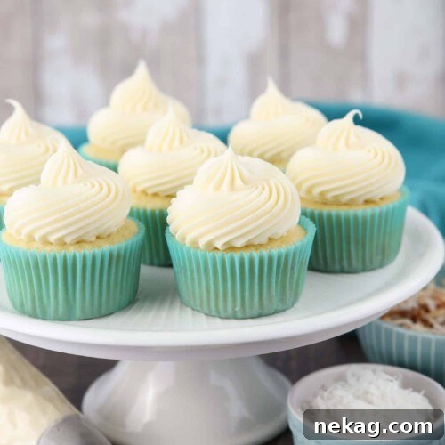 Big swirls of coconut cream cheese frosting piped onto cupcakes.