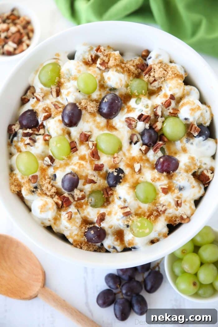 Creamy Grape Salad Recipe with Crunchy Pecans and Sweet Dressing 3 Top view of a creamy fruit salad with red and green grapes, pecans, and brown sugar.