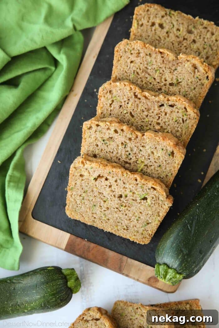 Slices of soft zucchini bread on a serving platter.