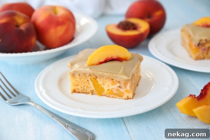 A square piece of peach cake with brown sugar frosting on a plate.