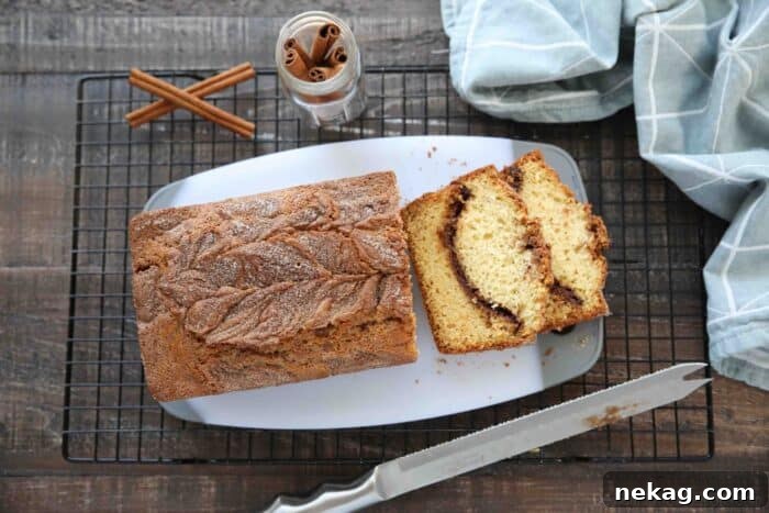 Ultimate Cinnamon Quick Bread Recipe — Moist & Spiced Loaf 10 Top view of cinnamon quick bread being sliced on a cutting board.