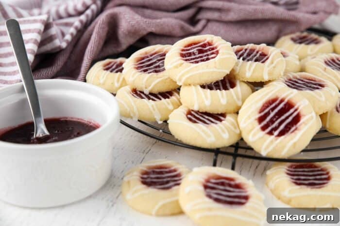 Thumbprint cookies stacked on top of a wire cooling rack.