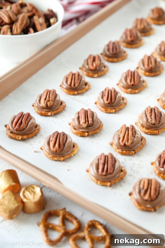 Rolo Pretzel Turtles on a baking sheet.