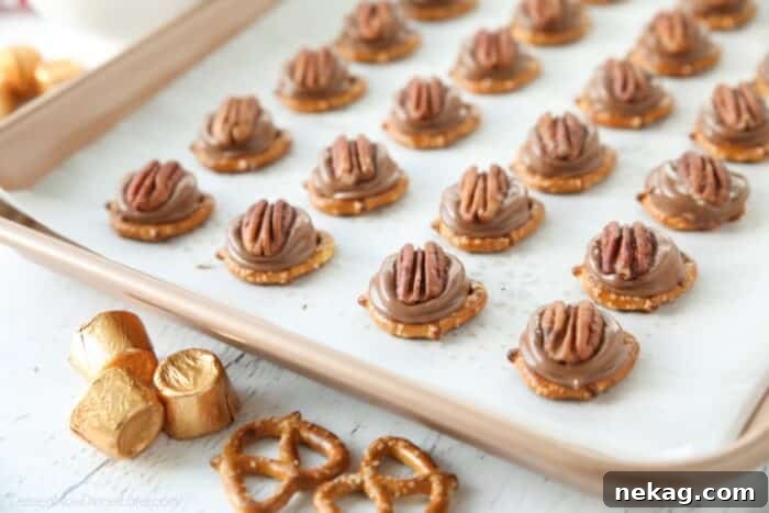 Rolo Pretzel Turtles on a baking sheet.