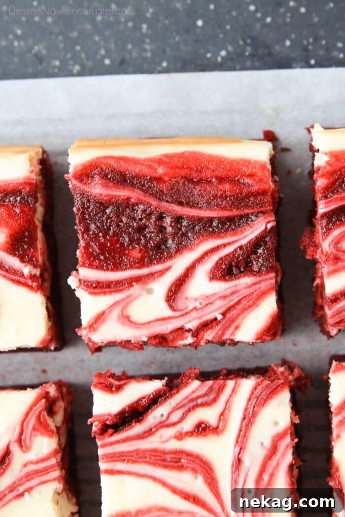 Squares of red velvet brownies with cheesecake swirled on top.