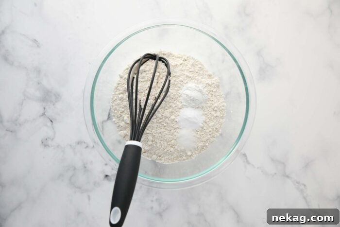 Dry ingredients in a bowl with a whisk.