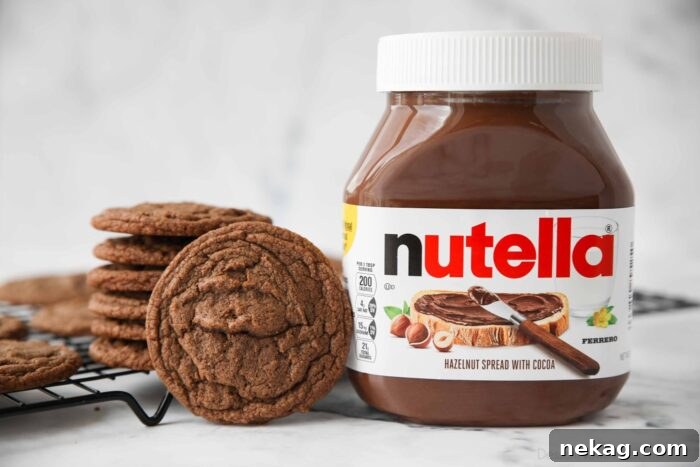 Decadent Nutella Cookie Recipe: Quick Homemade Chocolate Hazelnut Cookies 8 Jar of Nutella next to some cookies.