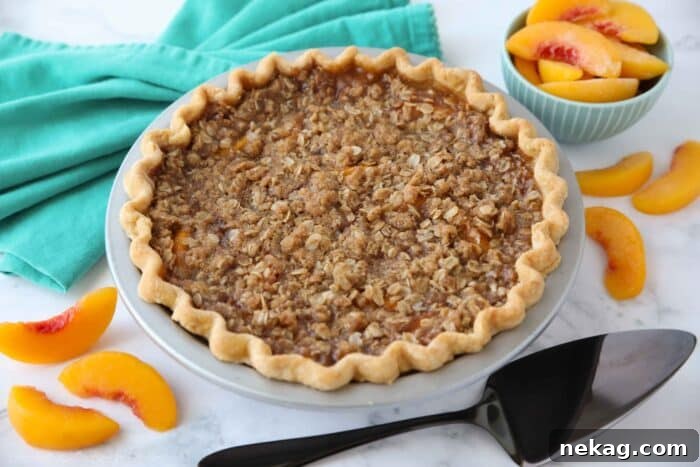 Fully baked peach crumble pie in pan.