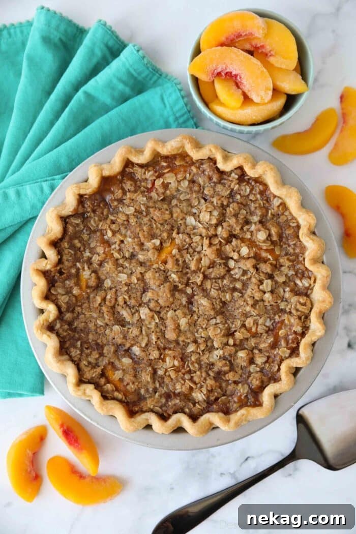Top view of baked peach crumb pie in pan.
