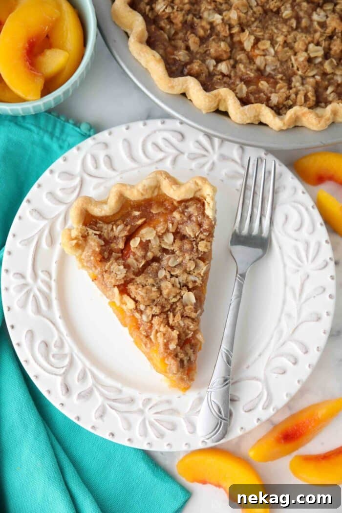 Top view of peach crumble pie on a plate with a fork.
