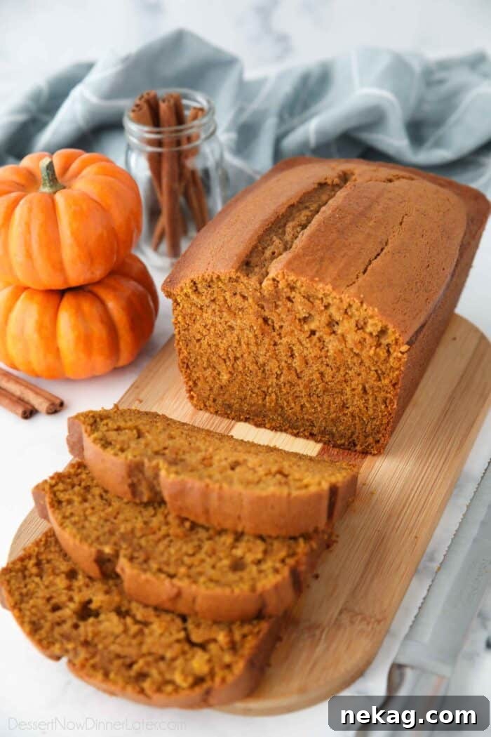 Moist Spiced Pumpkin Loaf Recipe for Autumn Baking 2 Loaf of pumpkin bread on a cutting board with some slices cut.