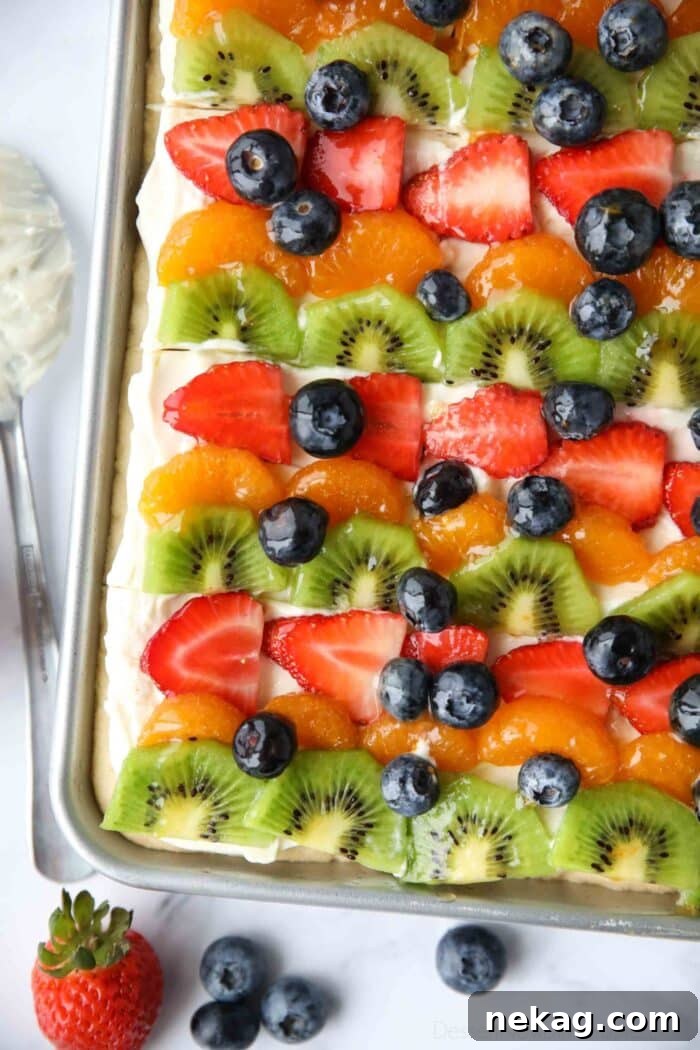 Top view of sugar cookie fruit pizza bars with cream cheese frosting.
