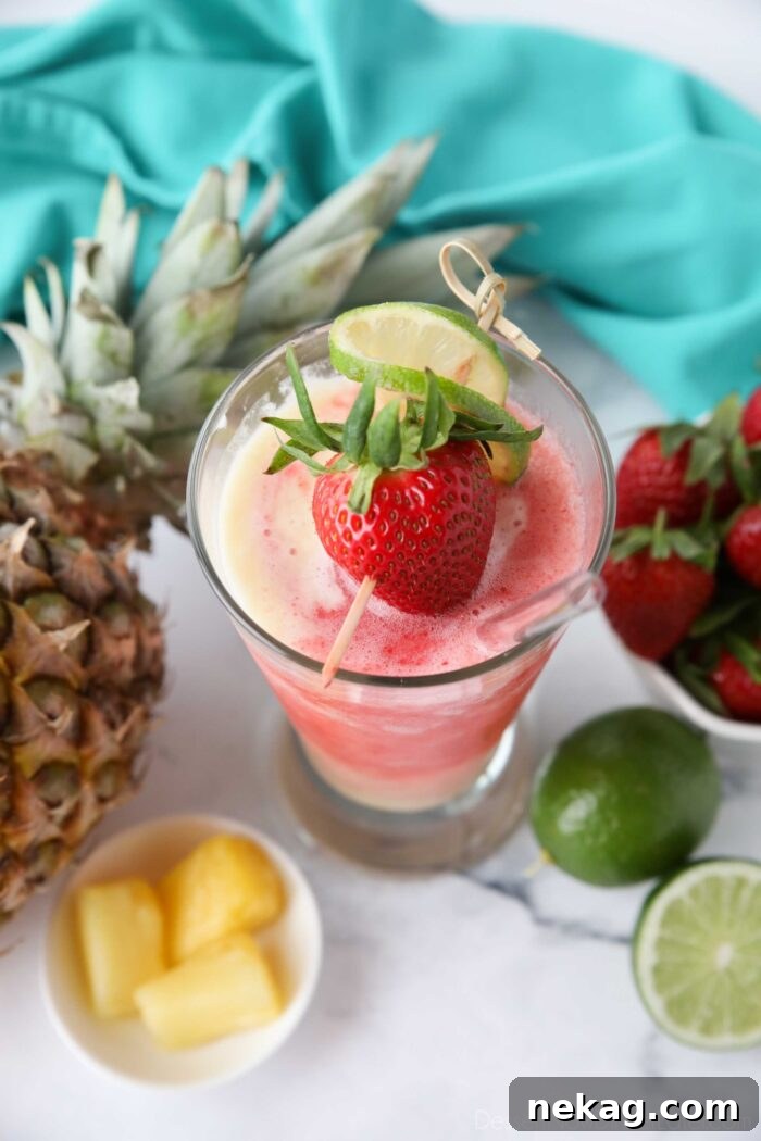 Top view of Virgin Miami Vice Drink in a tall glass with a strawberry and lime garnish.