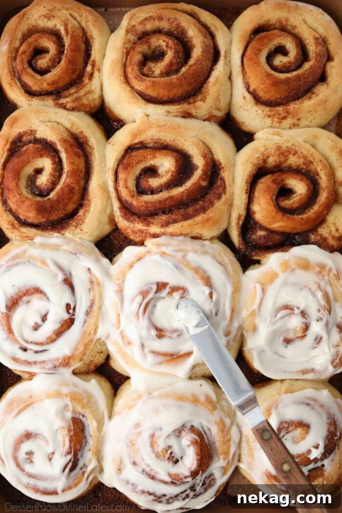 Homemade Cinnamon Rolls with Gooey Cream Cheese Frosting 4 Spreading cream cheese frosting on top of homemade cinnamon rolls.