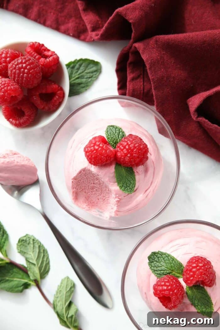 Light and Luscious Raspberry Mousse Recipe 4 Spoonful of raspberry mouse taken out of a small bowl.