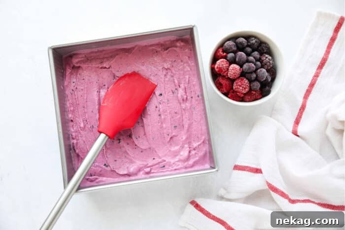 Berry frozen yogurt being spread into a shallow pan to freeze.